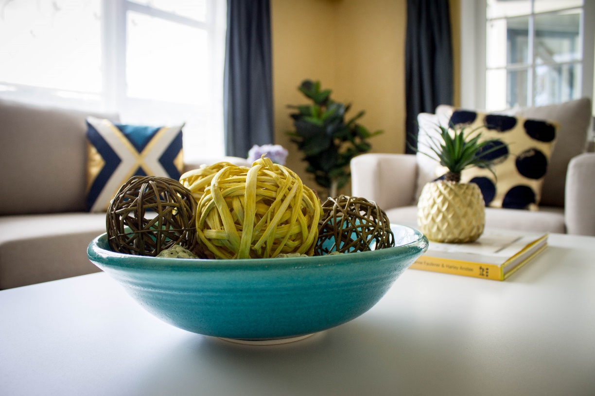 A home staged table decorated with a bowl and a plant