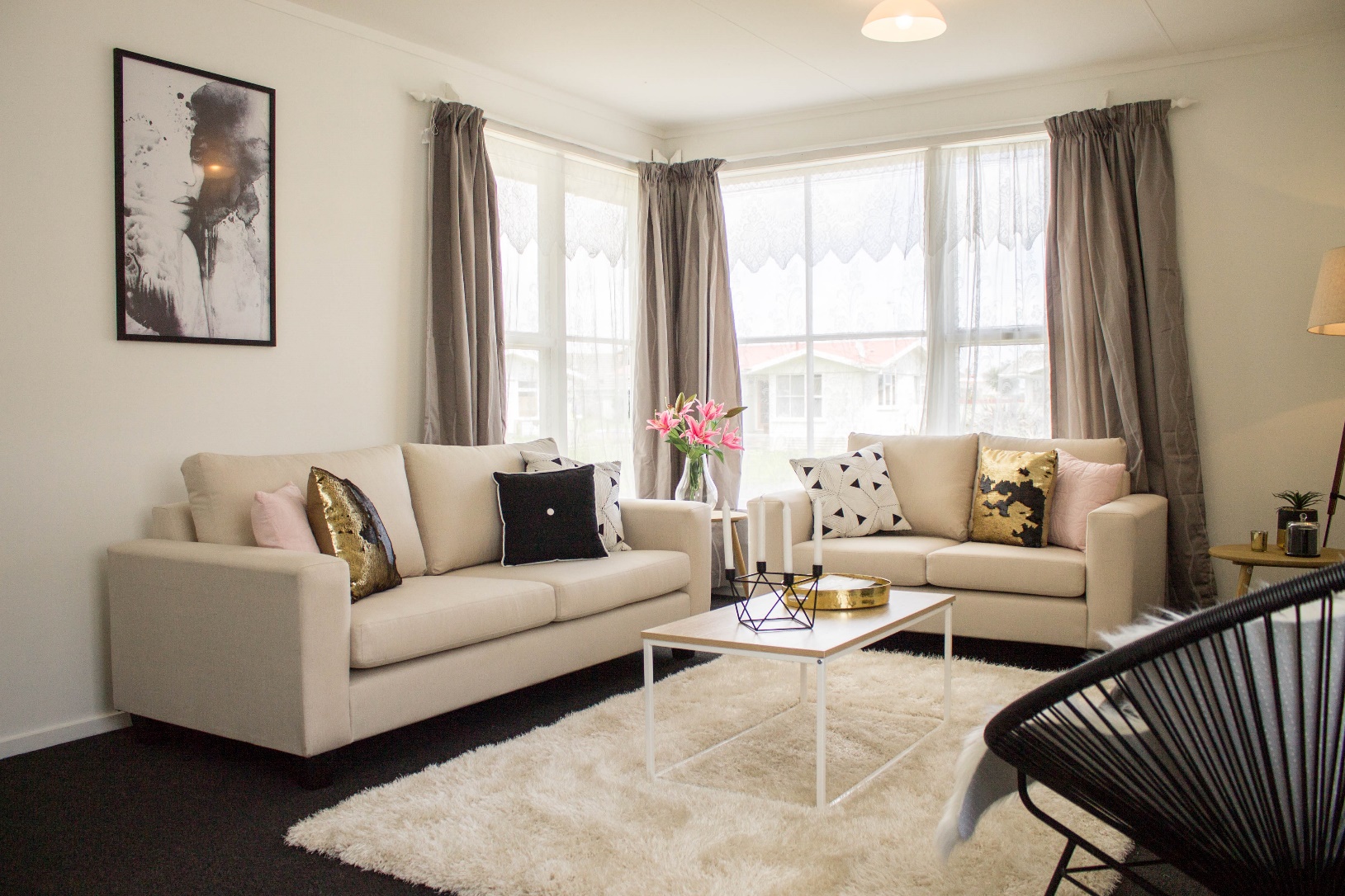 A homestaged lounge room with couches, a rug and accessories