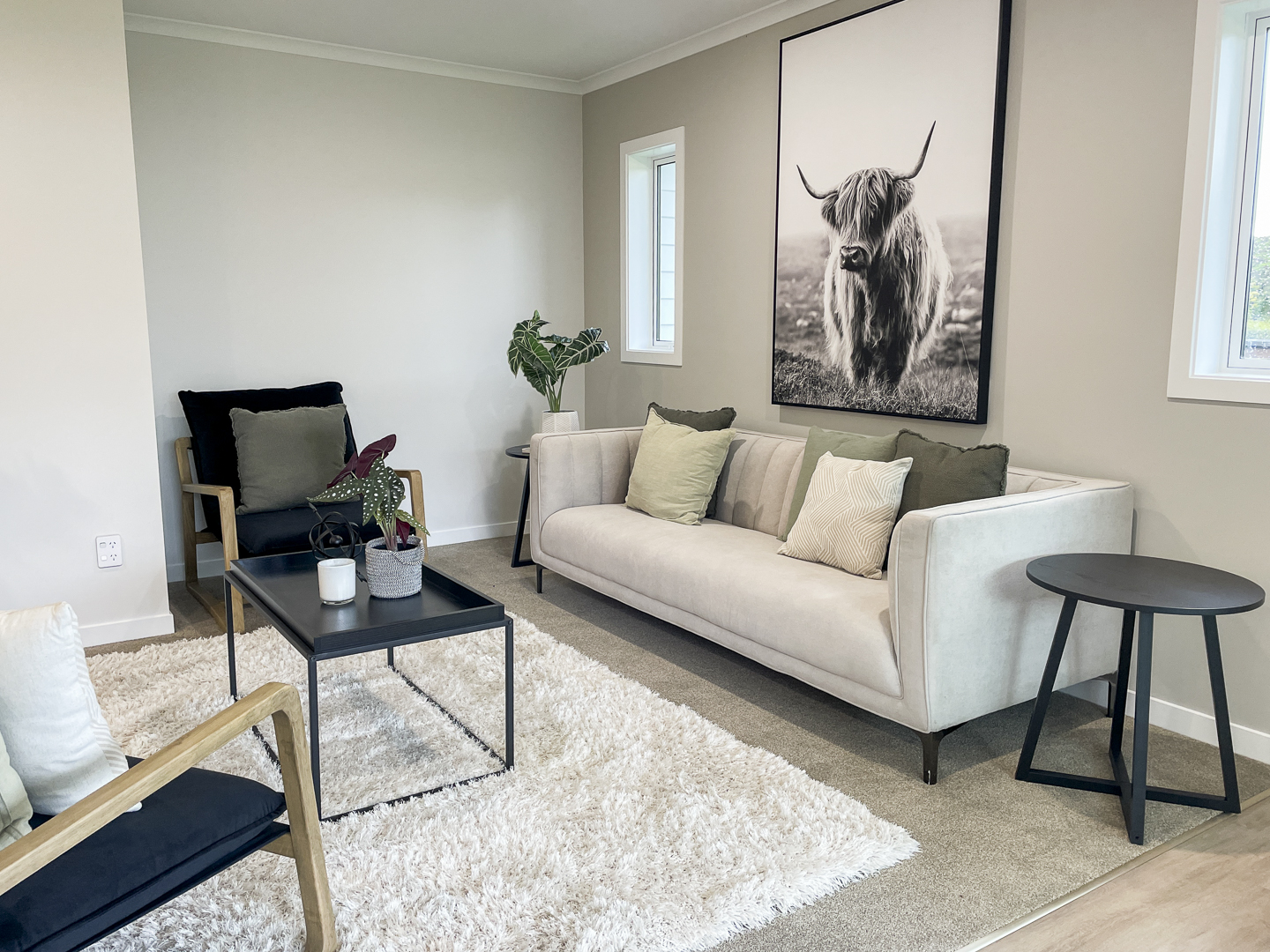 A home staged living room with a couch, coffee table, and rug.